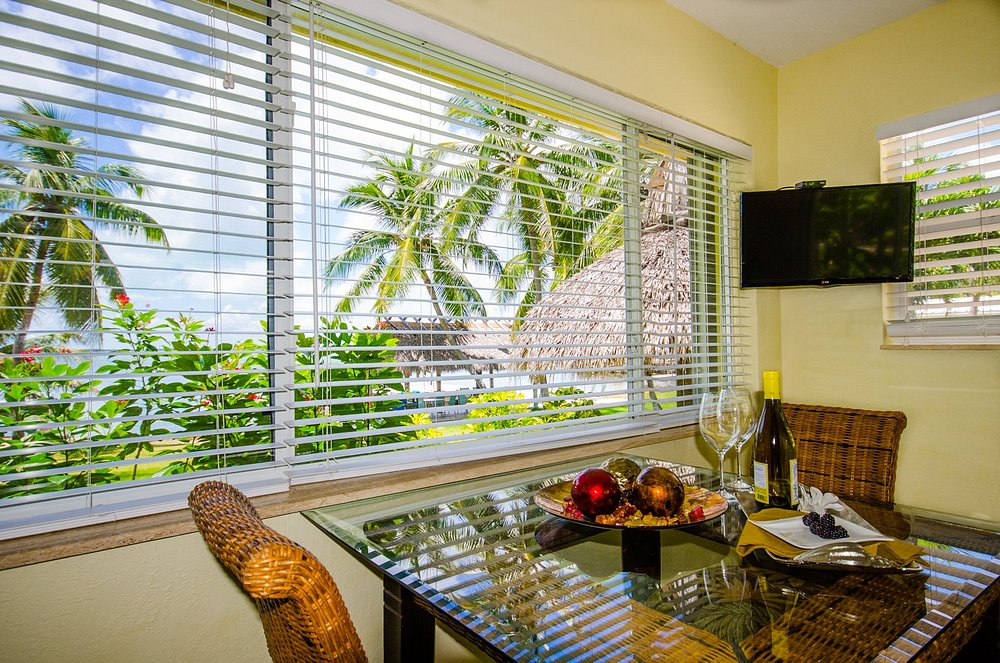 Dining nook inside the resort with tropical waterfront view through wide windows